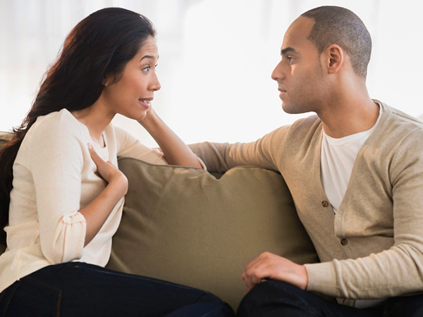 Married couple talking on couch